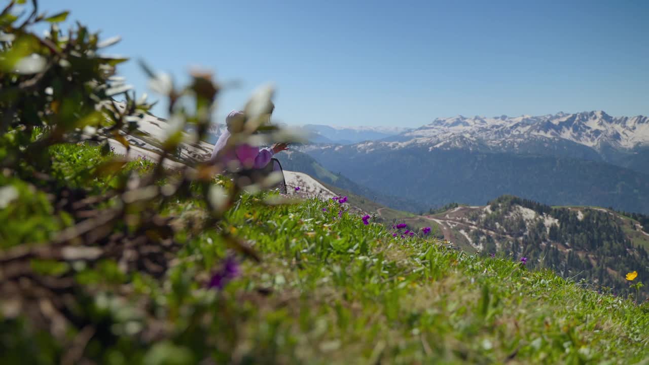 女孩徒步旅行者在山坡上休息时使用手机，俯瞰四周视频素材