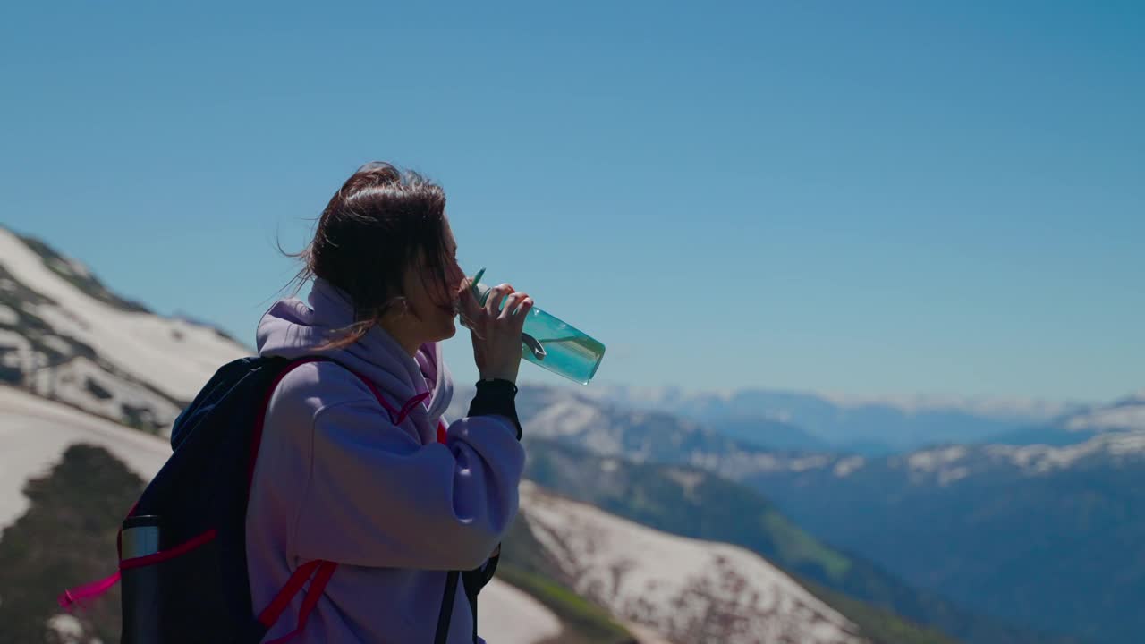 筋疲力尽的女徒步者在攀登完山顶后，停下来休息视频素材