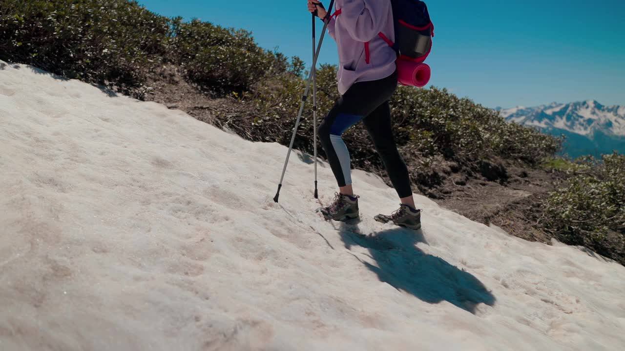 女孩徒步挑战越过雪坡，到达山顶视频素材