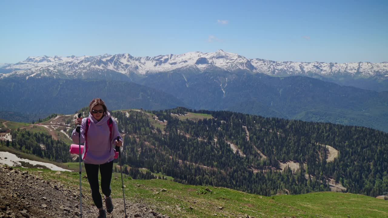 旅游探险队在山上，年轻女子正在攀登山顶视频素材