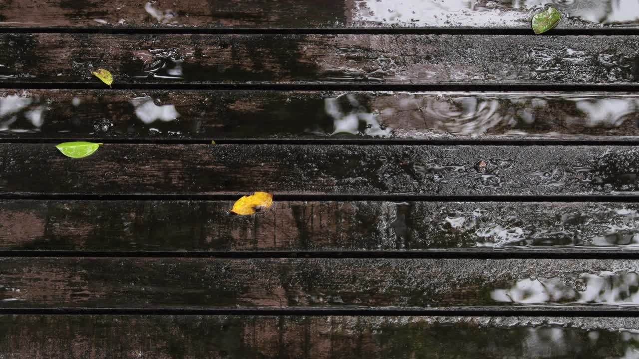 雨点落在木桥上。木桥上淅淅沥沥，概念享受轻松自然。视频素材