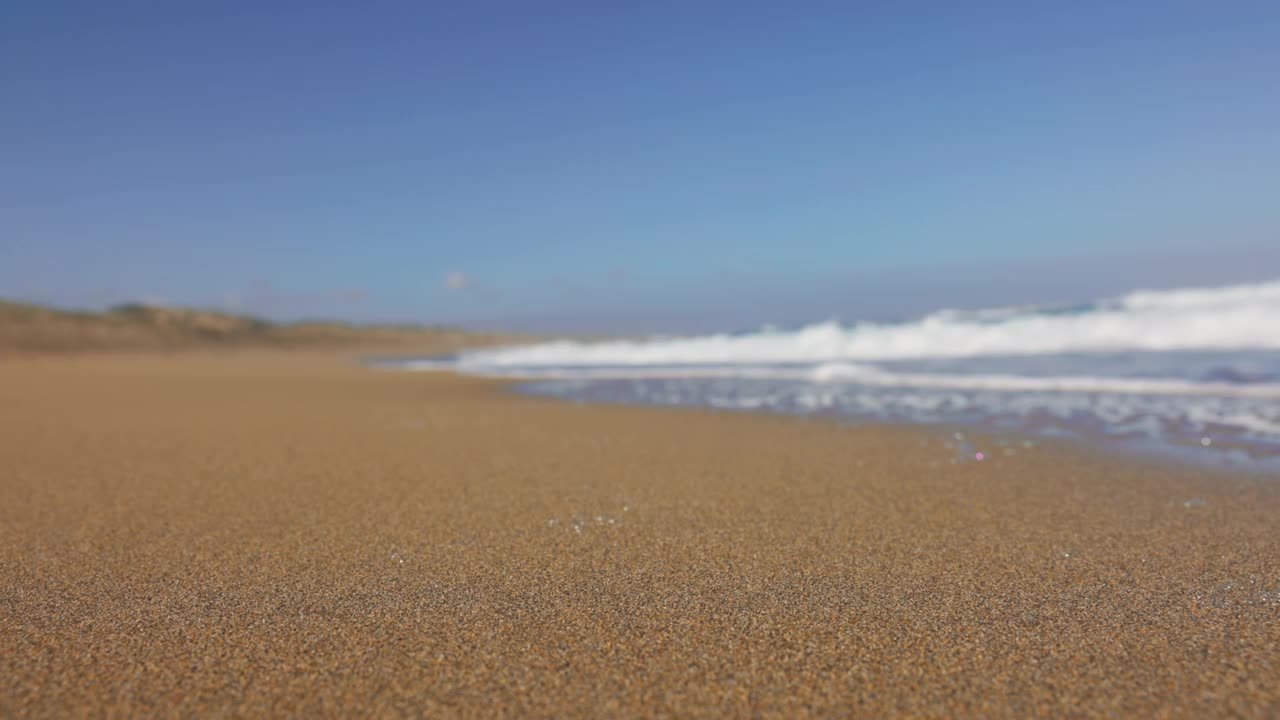 海浪在撒丁岛海滩上滚动的慢动作视图。视频素材