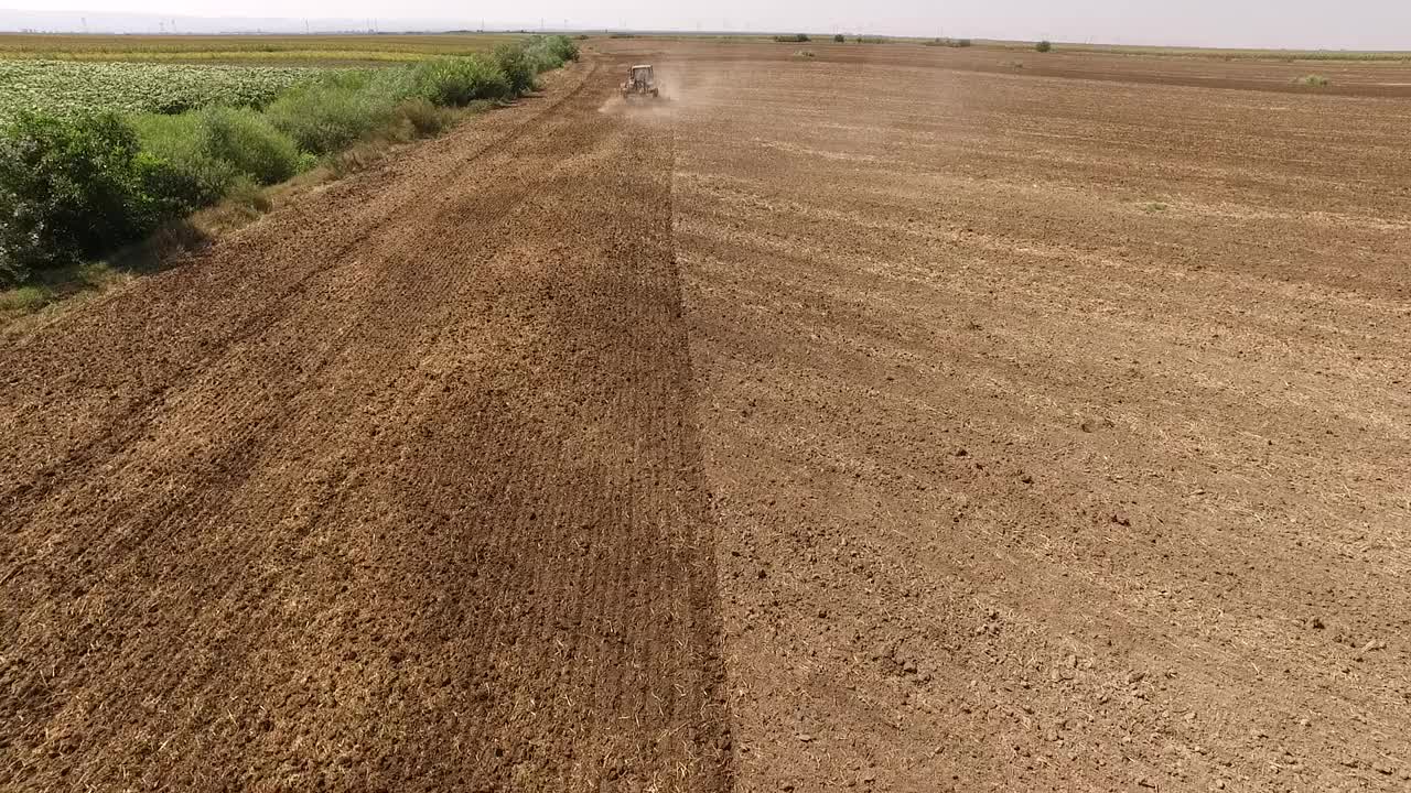 拖拉机耕作麦田的鸟瞰图视频素材