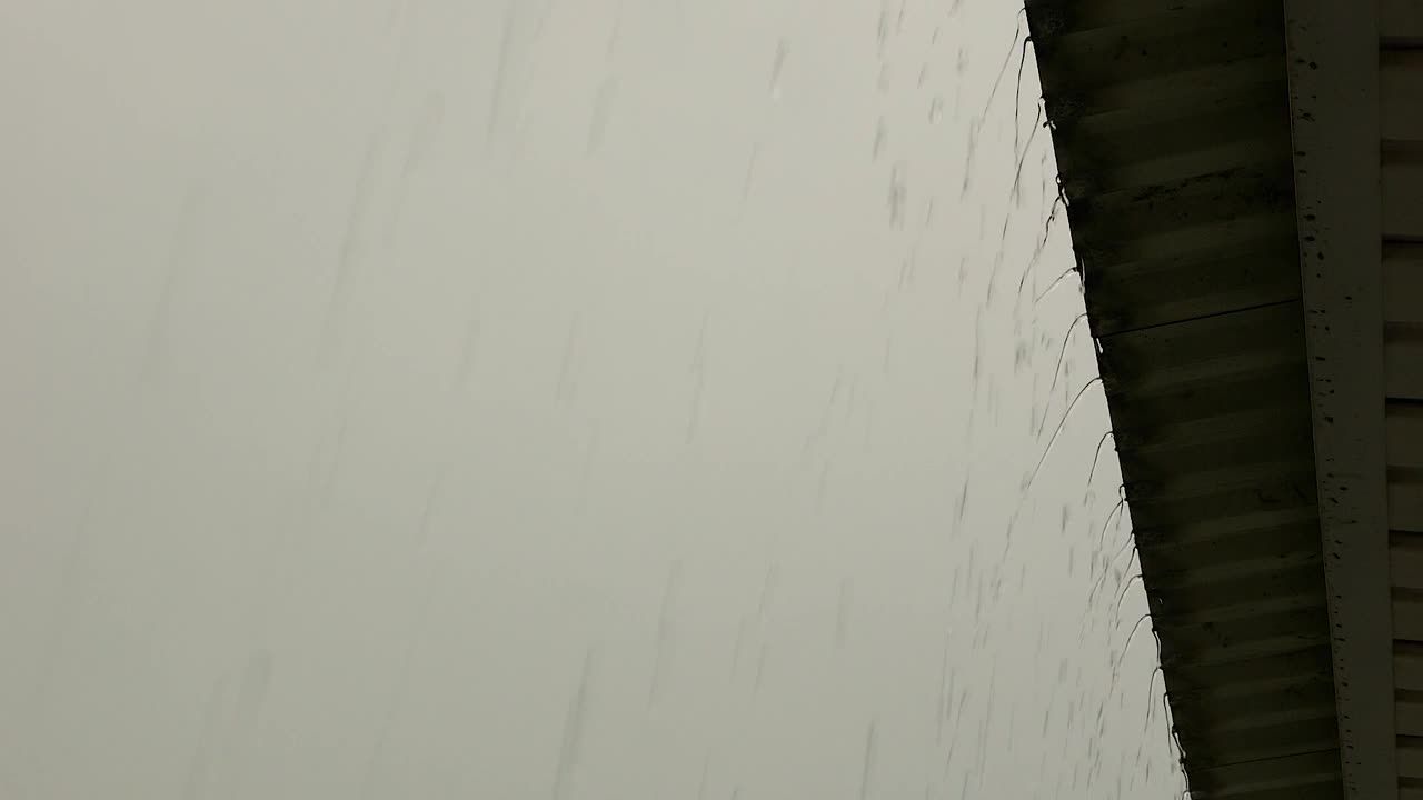 雨水很快地从屋顶流下来。夏天大雨时漏水。阴雨天气主题。有选择性的重点视频素材