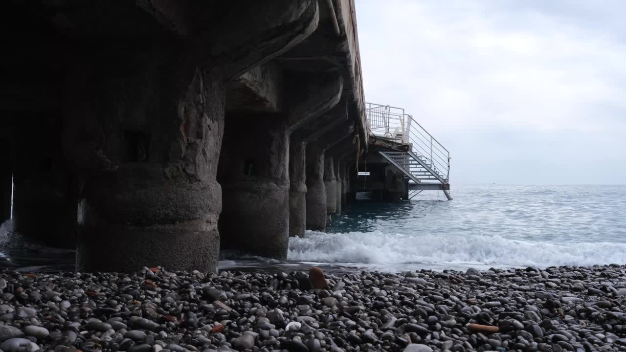 Minori海滩，Amalfi海岸，坎帕尼亚，意大利。海边的波浪与栈道的柱子横跨大海。视频素材