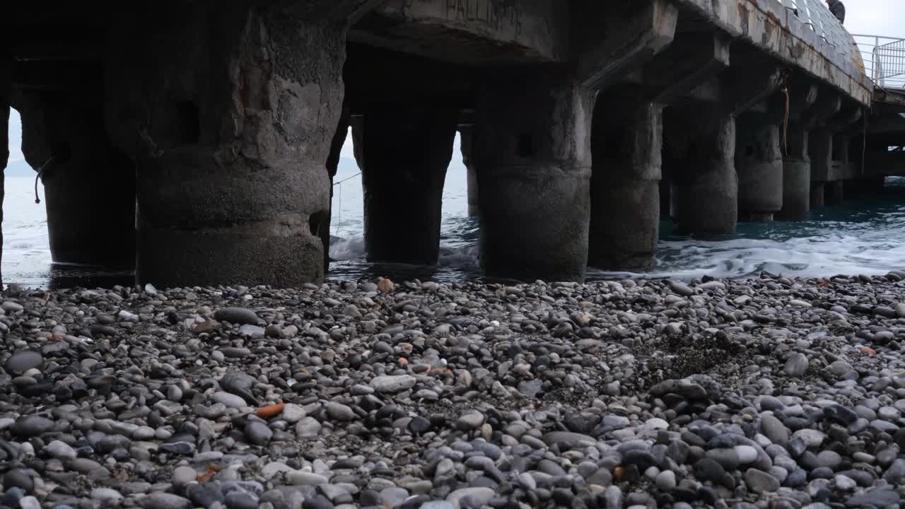 Minori海滩，Amalfi海岸，坎帕尼亚，意大利。海边的波浪与栈道的柱子横跨大海。视频素材