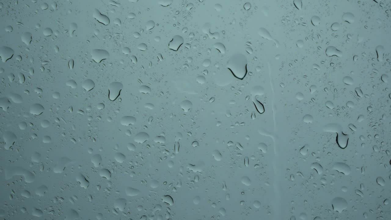 玻璃上的雨滴纹理。下落背景图像。雨天的概念。视频素材