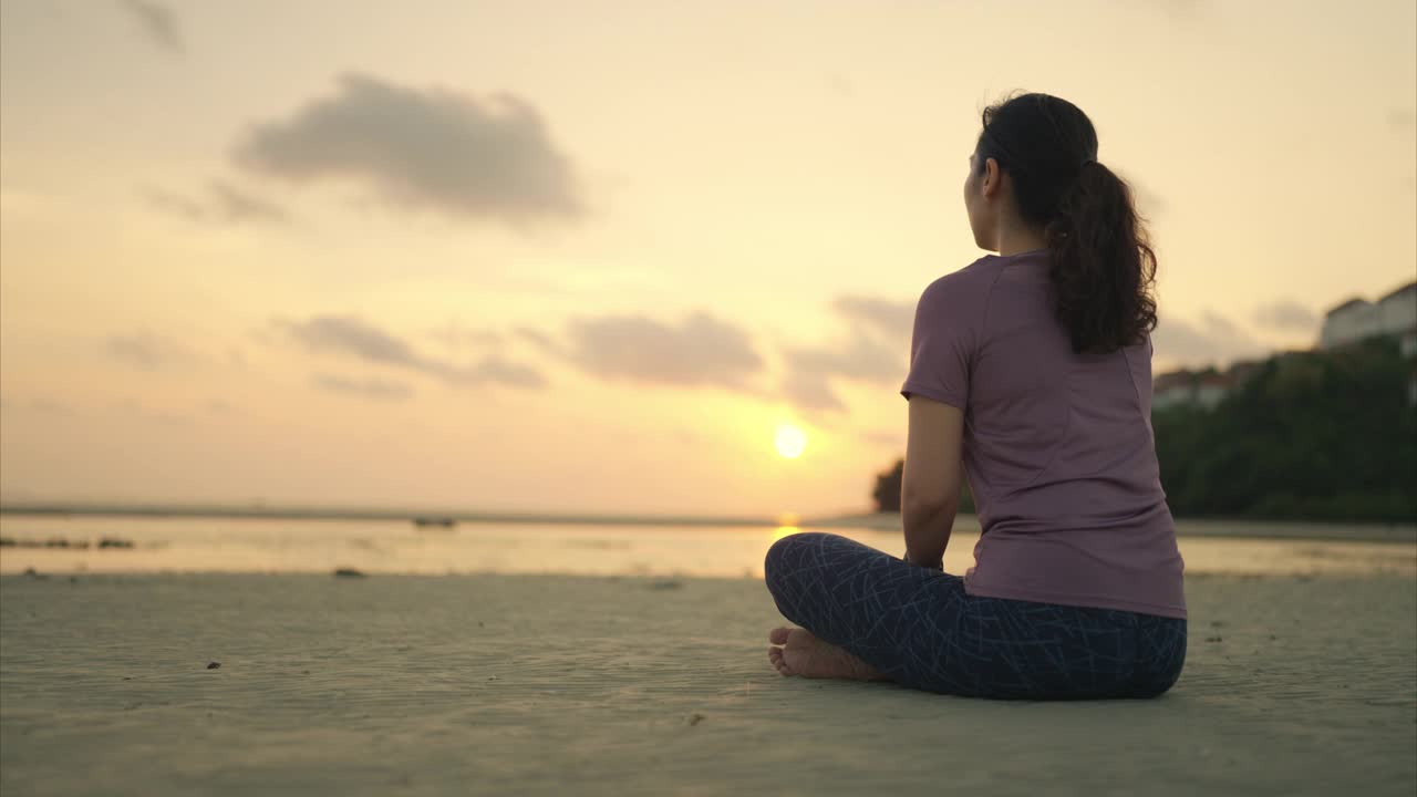 沙滩上莲花坐的女人视频素材