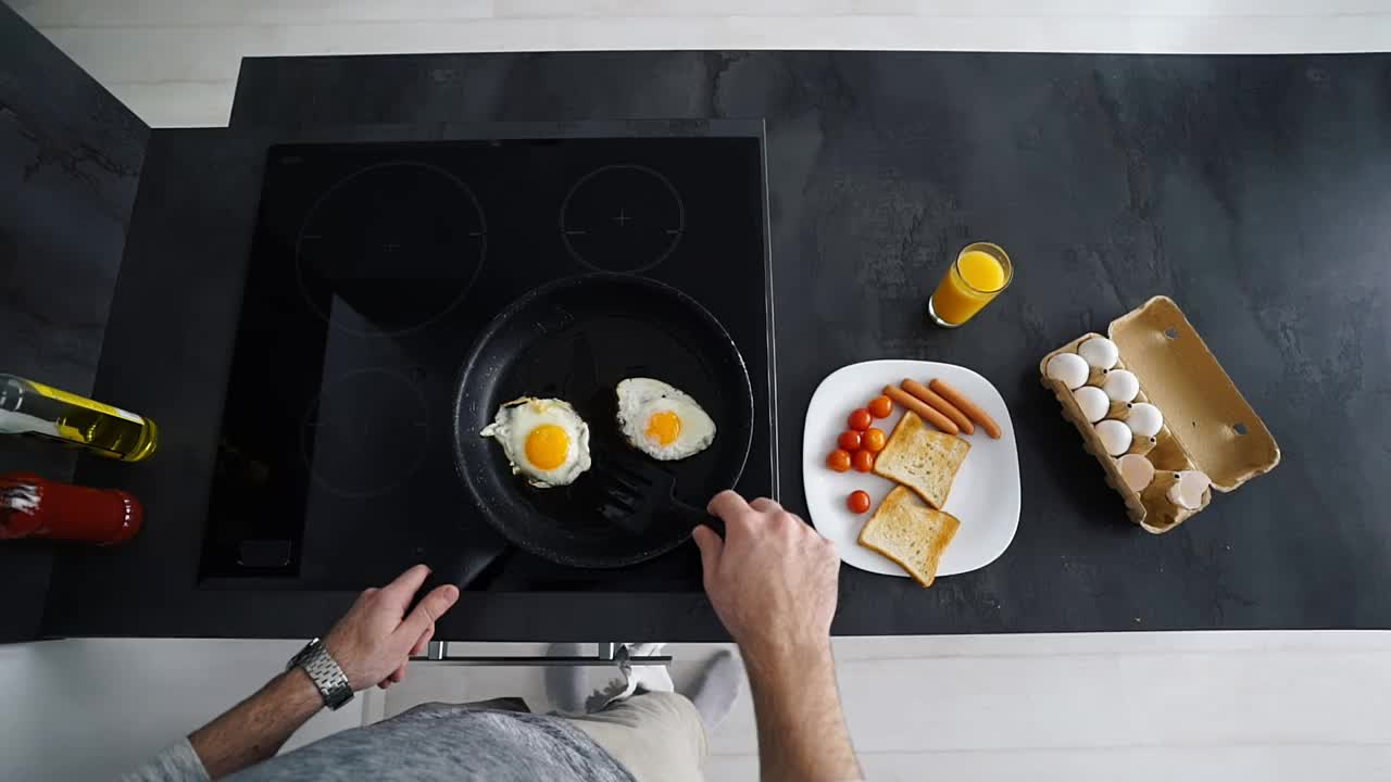 俯视图的单身男子正在厨房煎锅上做饭视频素材