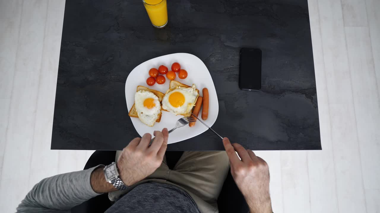 上图为单身男子在厨房煎锅上做饭视频素材