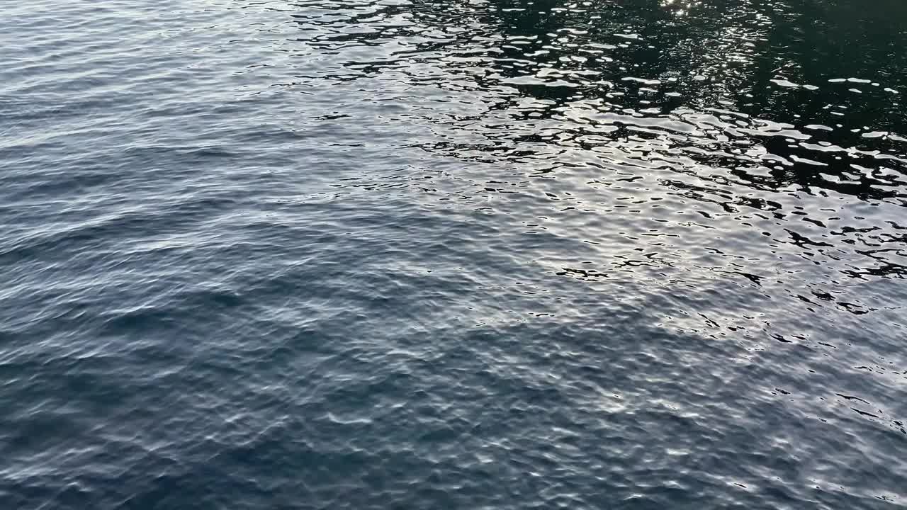 蓝色海水背景。深蓝色的波浪荡起涟漪。傍晚美丽闪亮的海景。视频素材