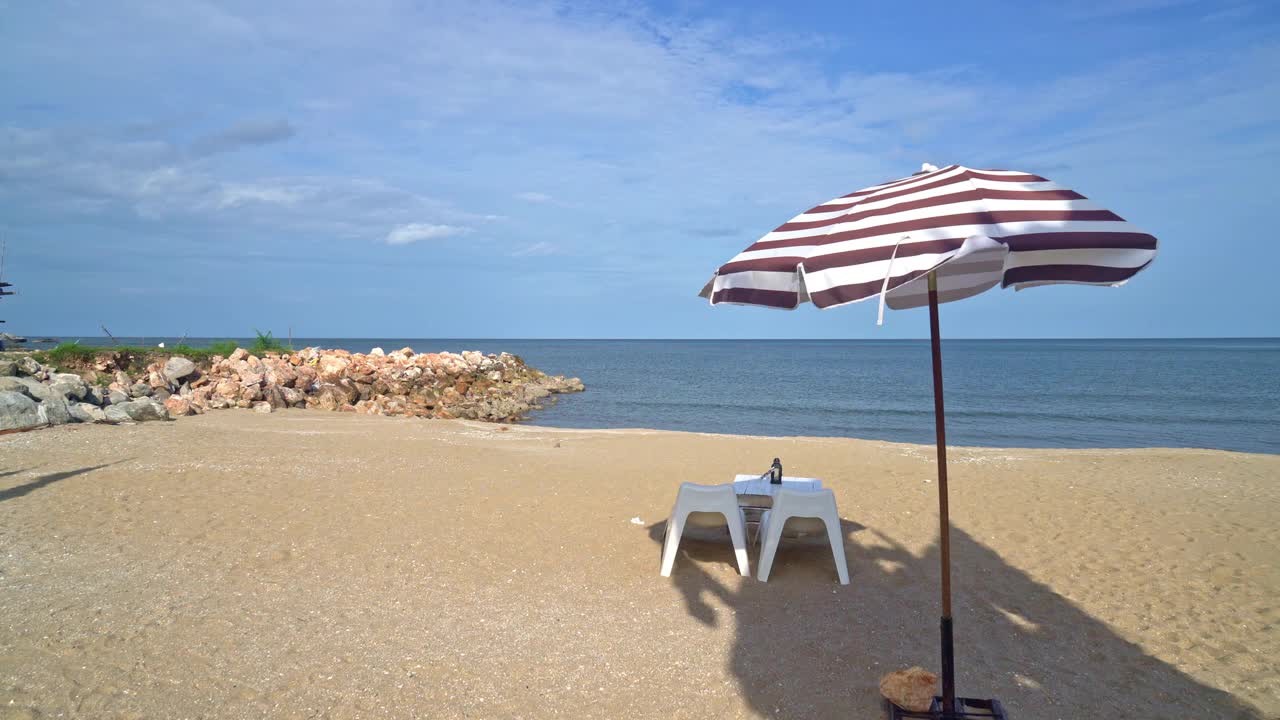 空旷的露台室外餐桌和椅子在海滩上与海滩的背景视频素材