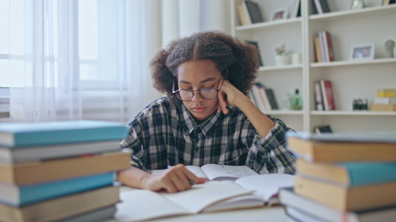 疲惫的大学生戴着眼镜做作业，学业压力大，受教育视频素材