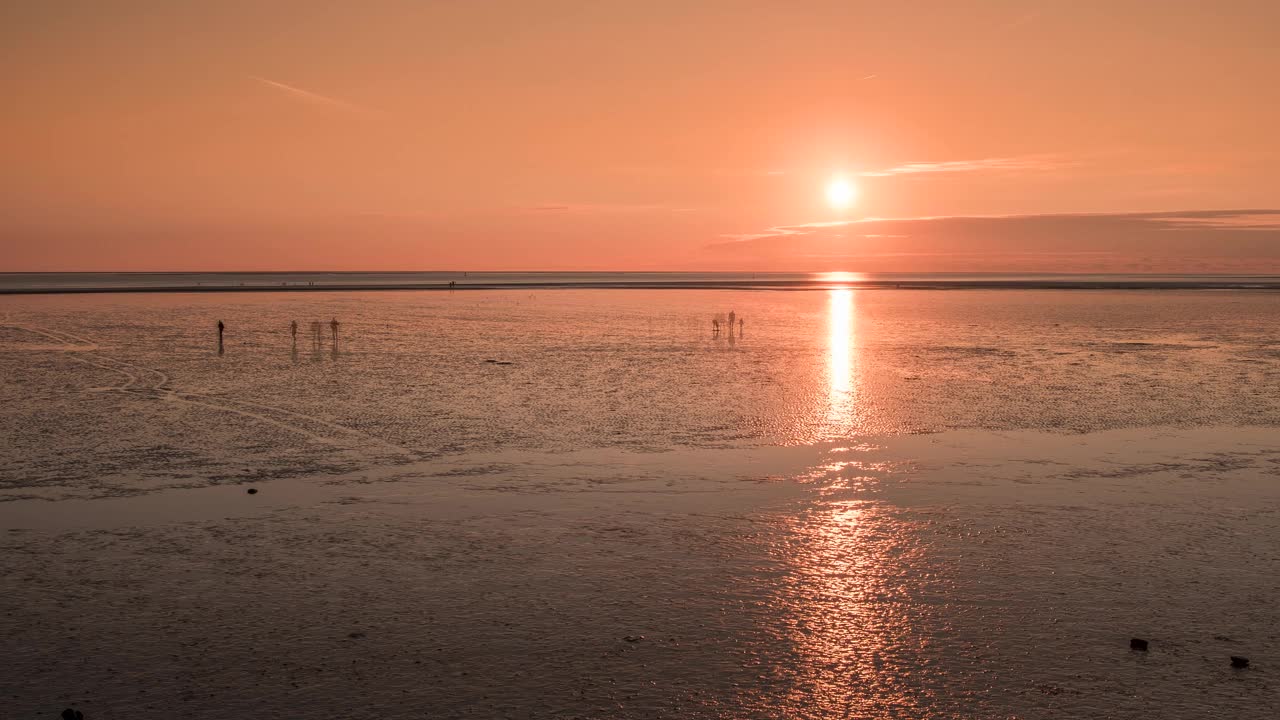 日落时分，布埃苏姆的瓦登海(Wadden Sea)上人们的剪影视频下载