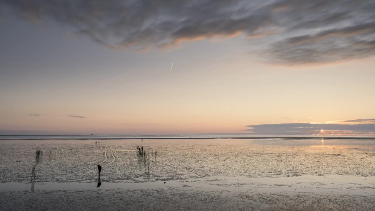 日落时分，布埃苏姆的瓦登海(Wadden Sea)上人们的剪影视频下载