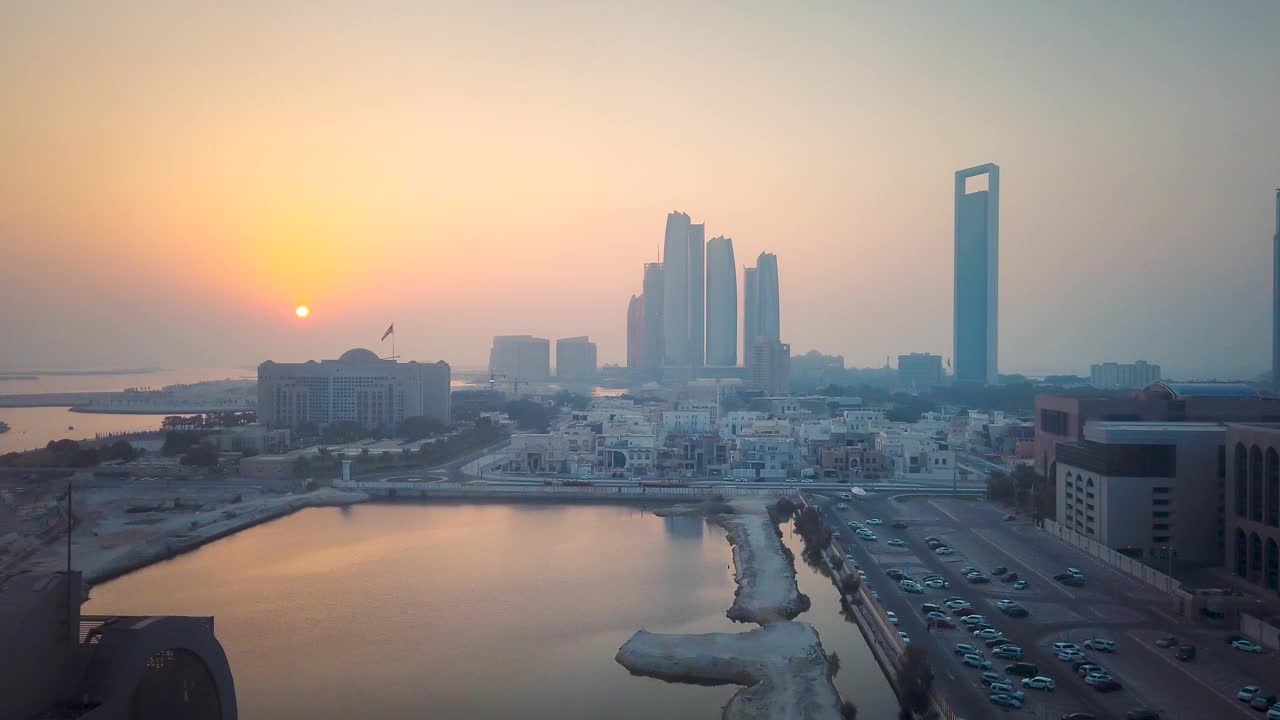 日落时分，阿布扎比地平线上的市中心建筑在水面上升视频素材