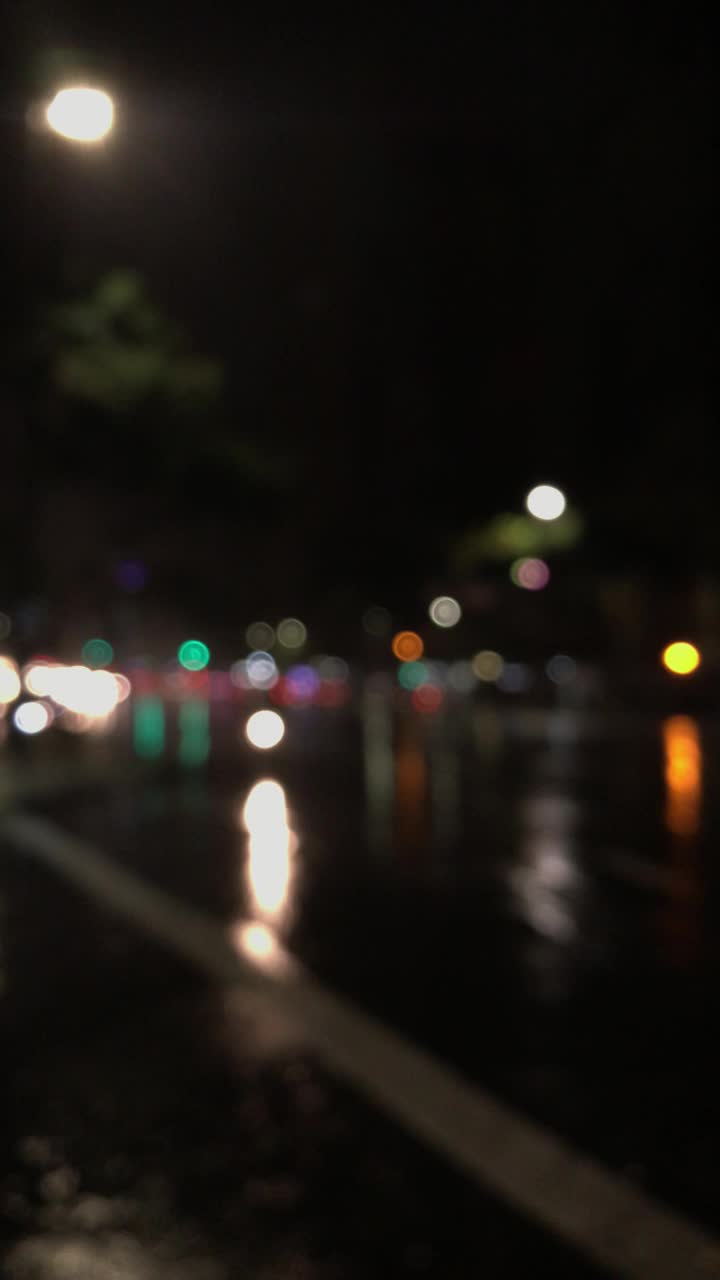 在雨中模糊了一条繁忙大街的背景视频素材