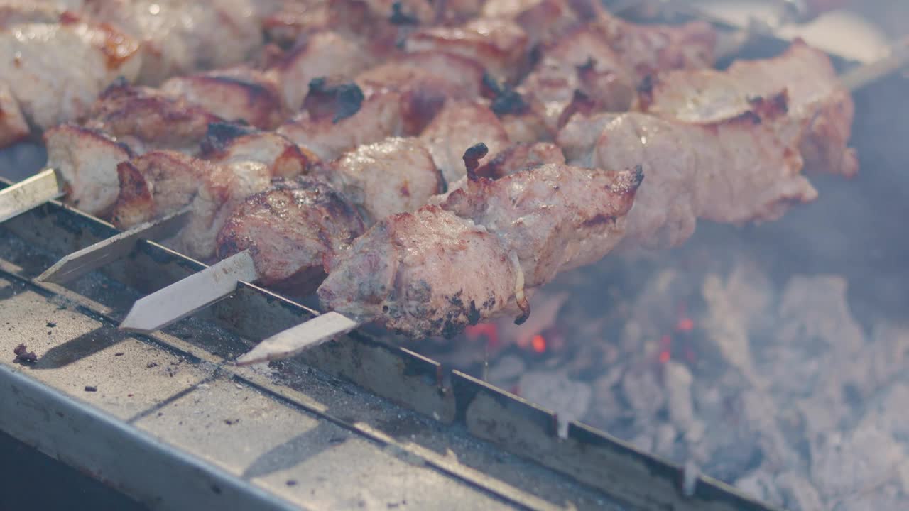 烤肉串上烤肉。在烤肉串上烤猪肉串街头食品视频素材