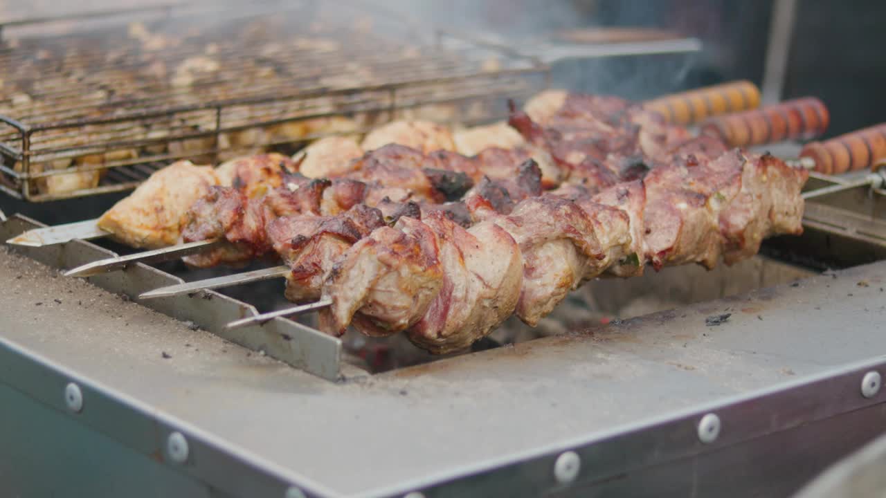 烤肉串上烤肉。在烤肉串上烤猪肉串街头食品视频素材