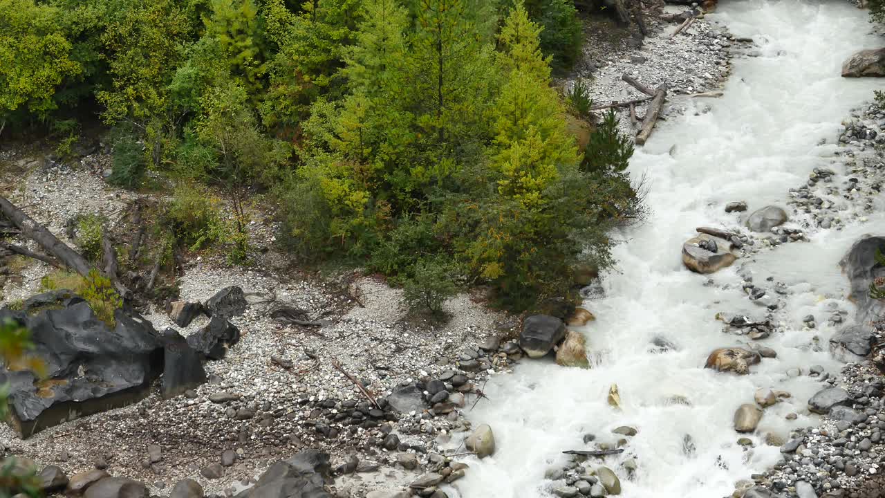 4k瀑布在山谷中流淌，绿色的针叶树，西藏波米县。视频素材