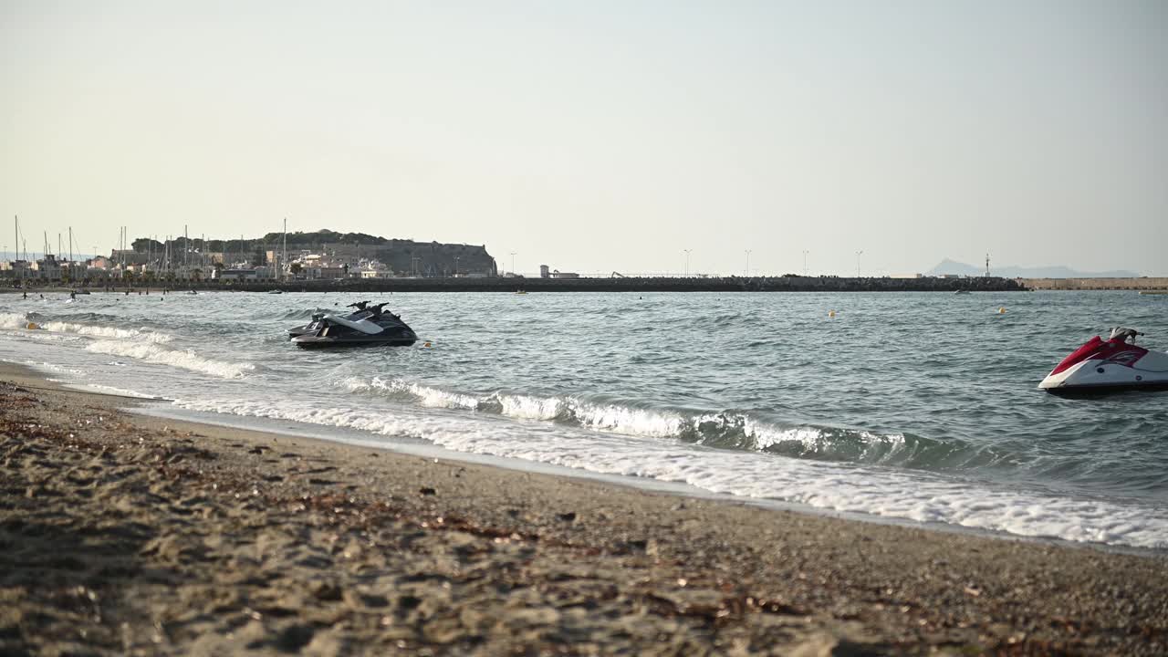 日落时分，摩托艇漂浮在地中海海滩的波浪上视频素材