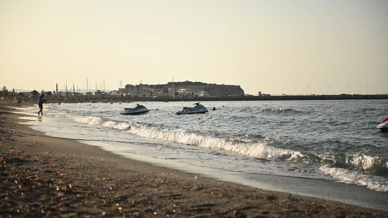 日落时分，摩托艇漂浮在地中海海滩的波浪上视频素材