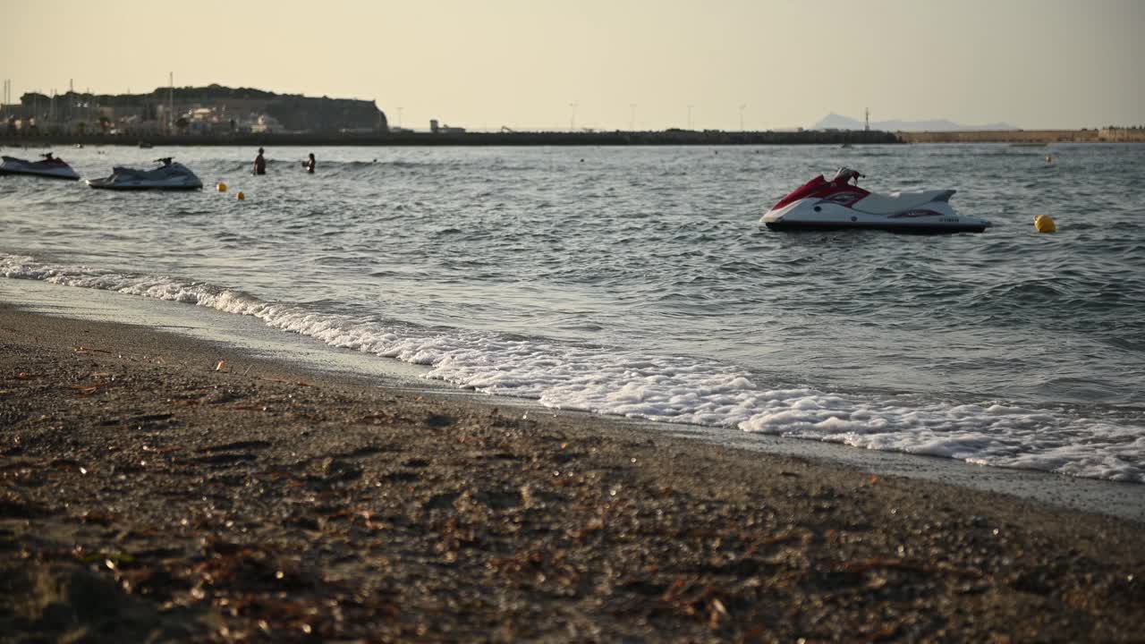 日落时分，摩托艇漂浮在地中海海滩的波浪上视频素材