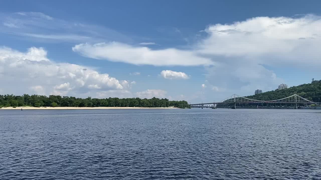 晴朗的夏日里，平静的河面上飘着云朵，水面泛起涟漪。视频素材