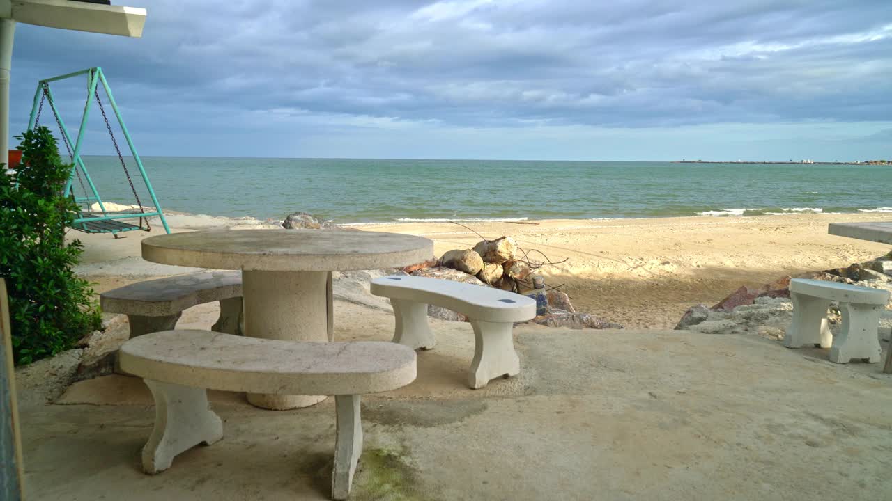 空旷的露台室外餐桌和椅子在海滩上与海滩的背景视频素材