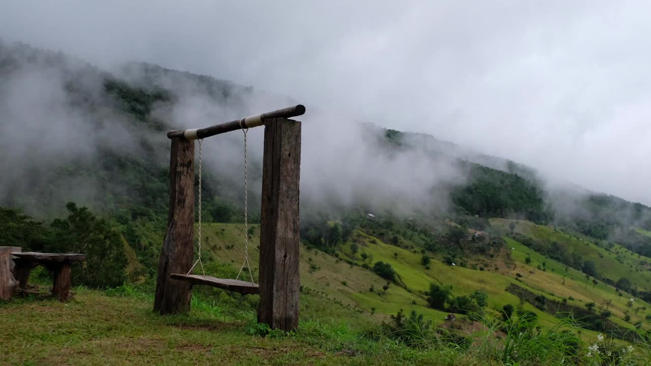 一个木制秋千和山景在雾天视频素材