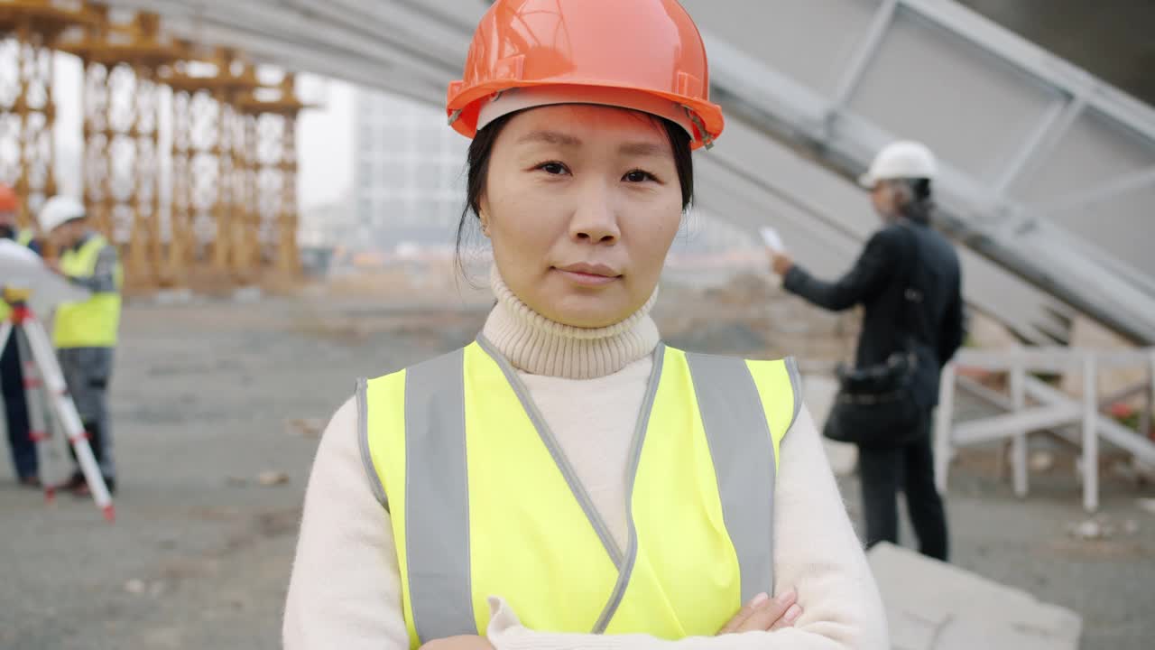 身穿制服的亚洲年轻女子肖像站在工地上视频素材