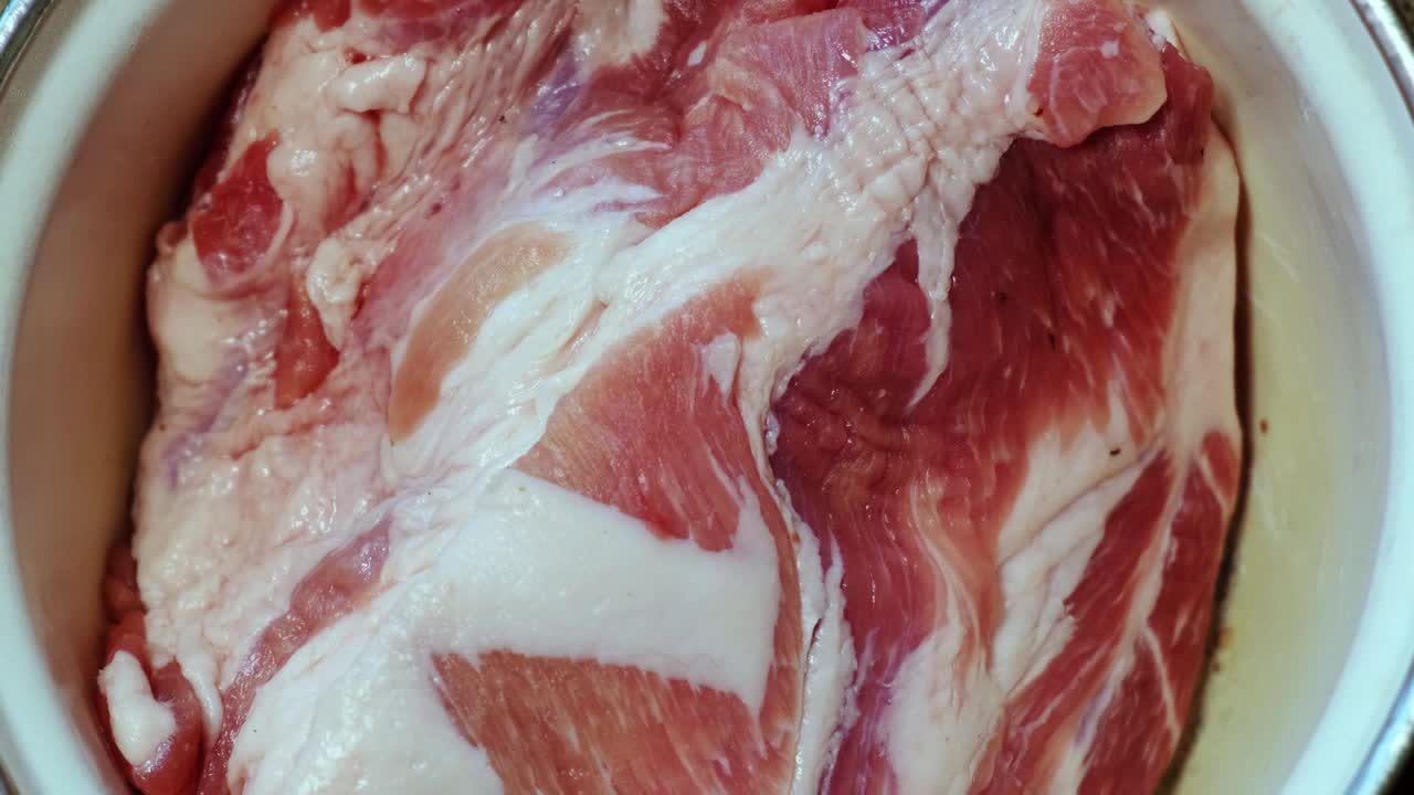 腌生肉。把腌梅子汁铺在一块新鲜的生肉上。视频素材