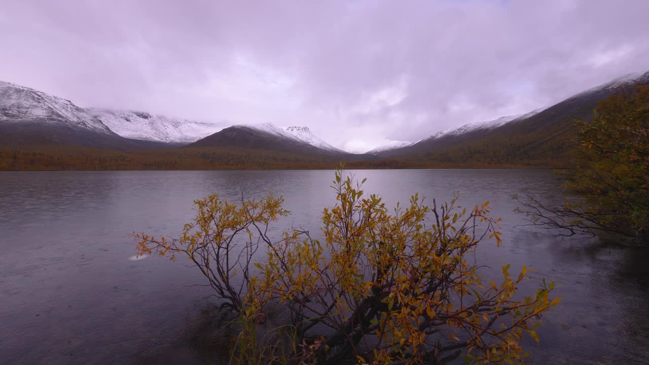 雨中的美丽山景。背景是积雪覆盖的山峰。希比尼山的秋天。视频下载