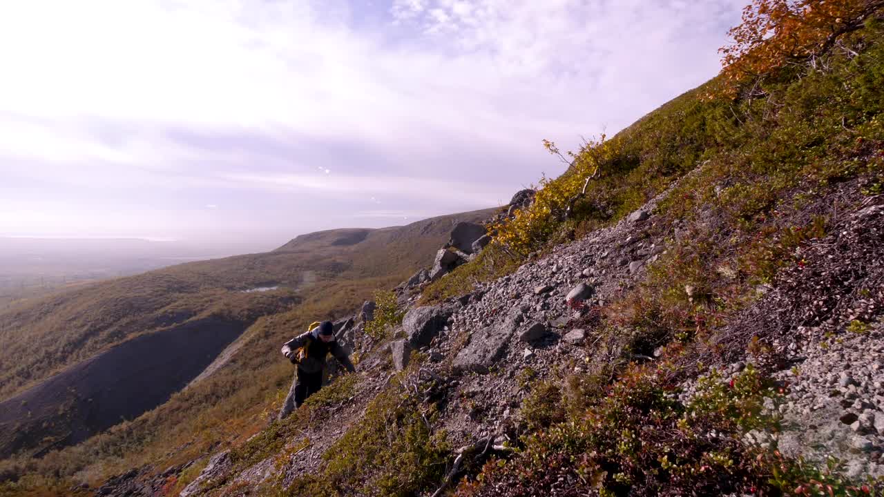 在山里背着背包的旅游者。秋日的希比尼山。美丽的山景。阳光下积雪覆盖的山峰视频素材