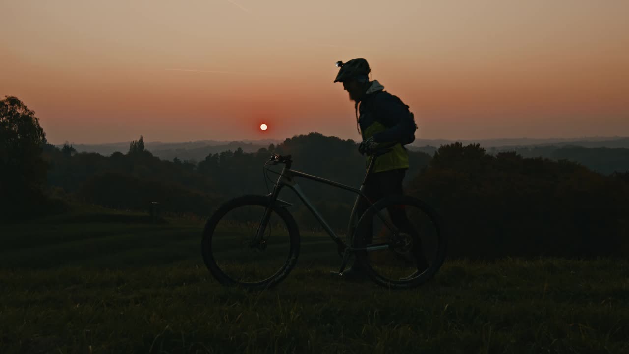 骑山地摩托车的人从山上欣赏乡村景色视频素材