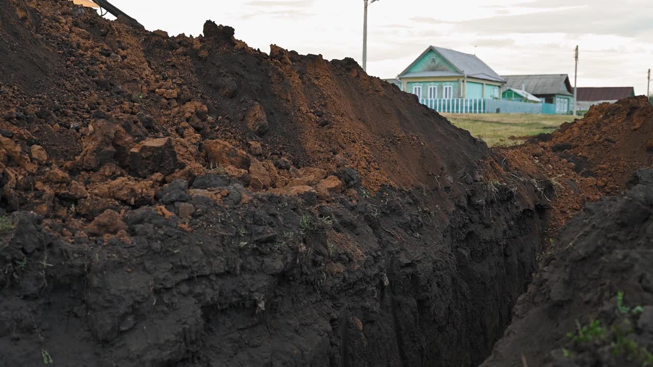 土方工程在农村。现代推土机在建筑工地掩埋壕沟视频下载