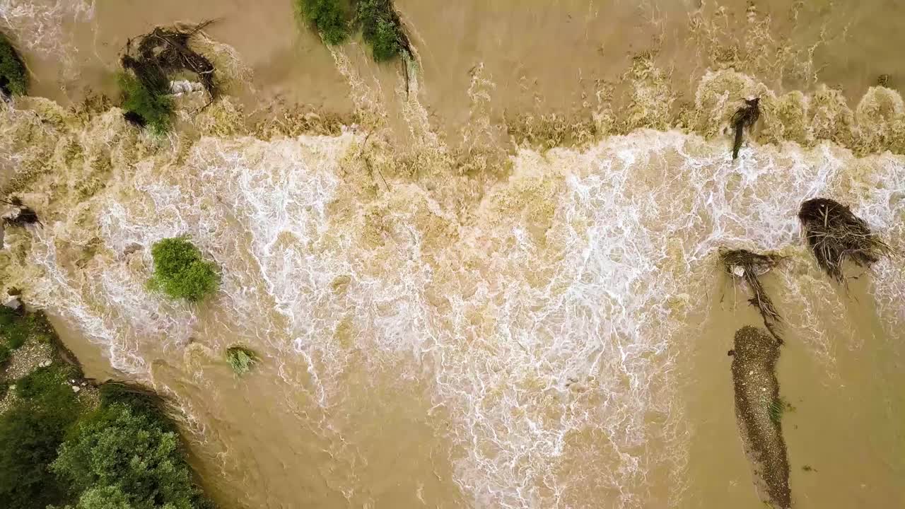 鸟瞰图宽阔的肮脏的河流与泥泞的水在洪水期间在暴雨的春天。视频素材