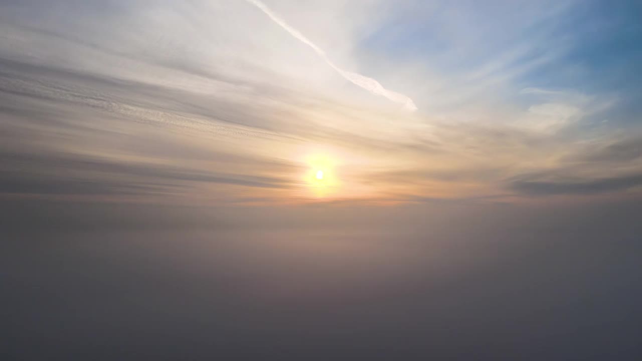 鸟瞰图，充满活力的黄色日出在白色浓密的云和蓝色的天空。视频素材