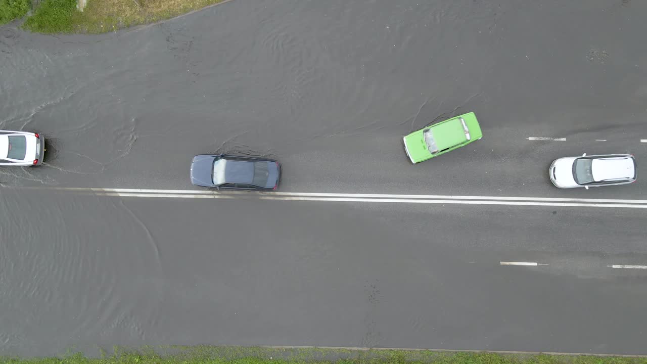 鸟瞰图的城市交通与汽车行驶在洪水后的街道。道路排水系统问题视频素材