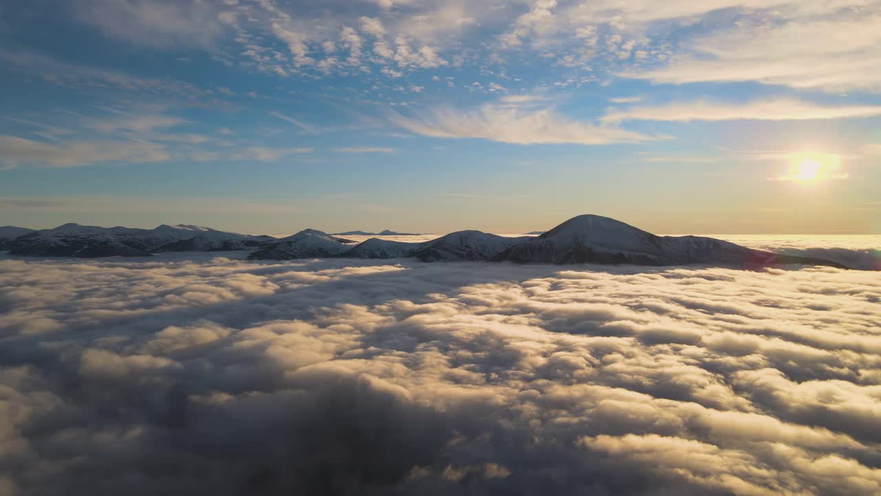 鸟瞰生机勃勃的日出在白色的浓雾与遥远的喀尔巴阡山脉的黑暗山峰在地平线上。视频素材