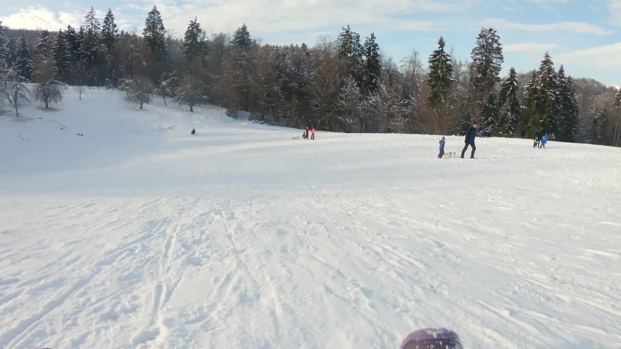 孩子在塑料铲雪橇上滑雪视频素材