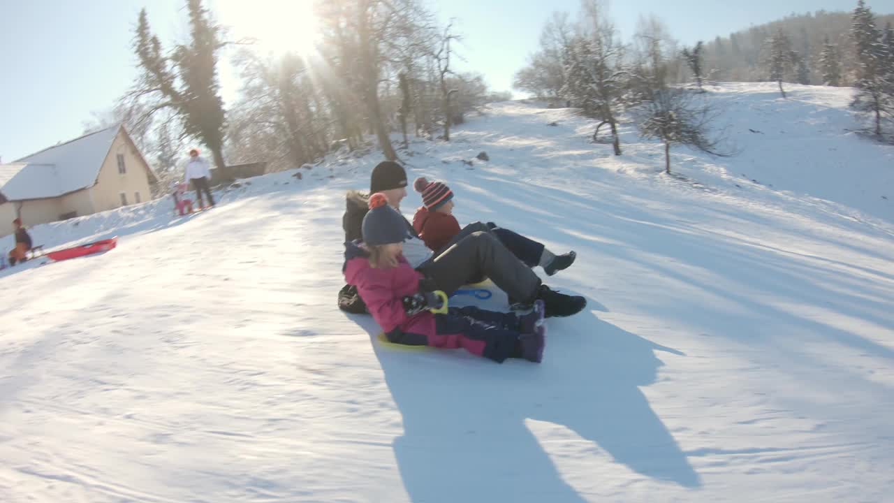 父亲和孩子们在雪地上玩耍视频素材