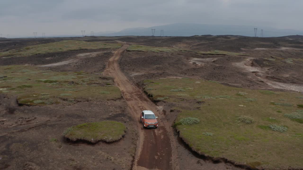 鸟瞰图跟踪汽车在冰岛的野生道路上移动。向前飞行在超现实的冰岛风景。冒险的公路越野车之旅视频素材