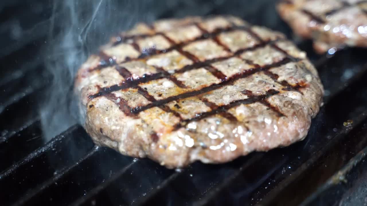 汉堡肉饼在烤架上。视频素材