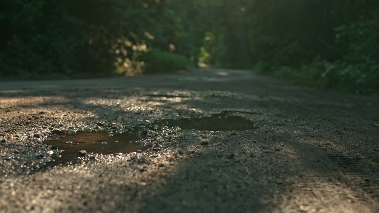 超级SLO MO山地摩托车手超速通过泥土路上的水坑视频素材