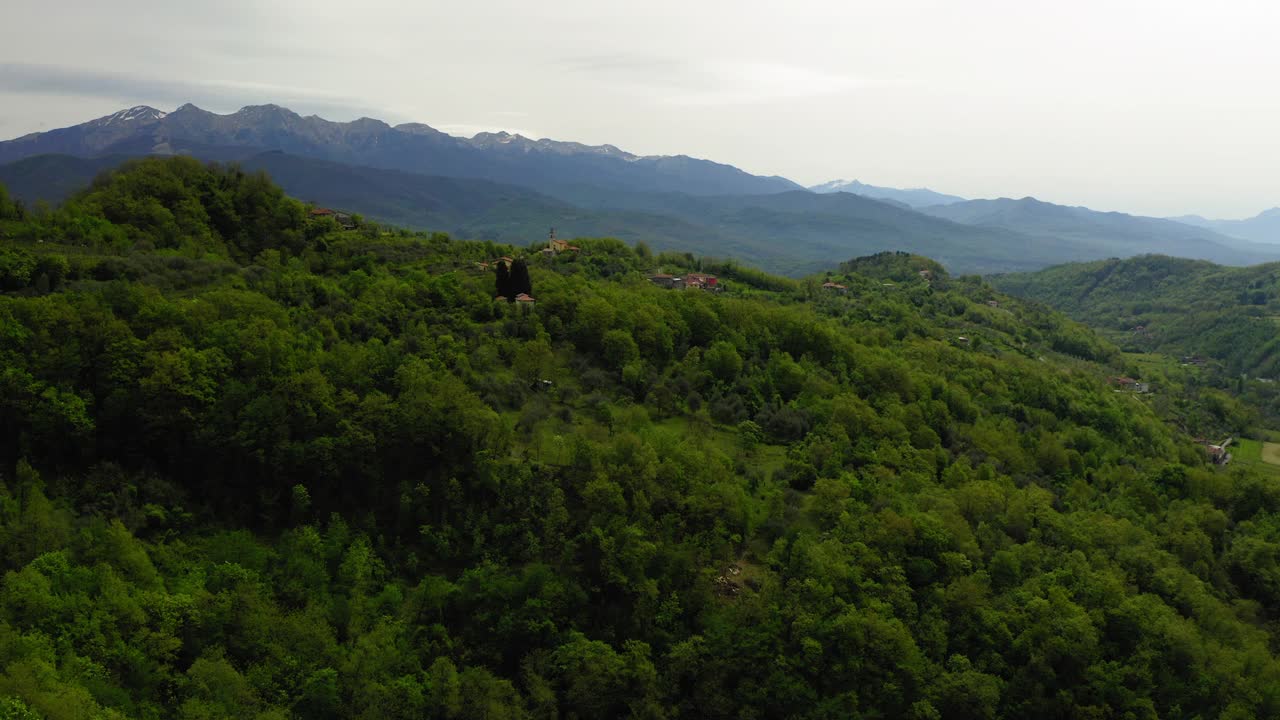 空中向前拍摄的住宅在绿色的树在山上-亚平宁山脉，意大利视频素材