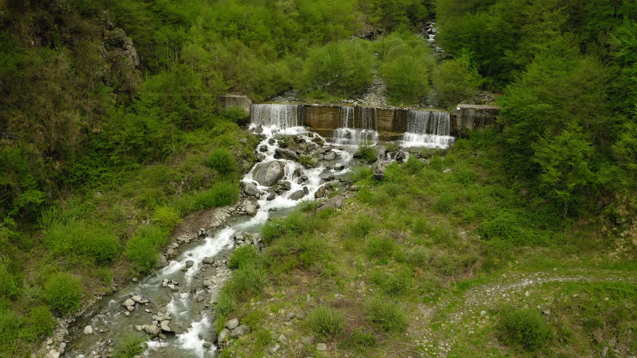 航拍:田园诗般的镜头，水在挡土墙上流动，无人机飞越绿色景观-亚平宁山脉，意大利视频素材