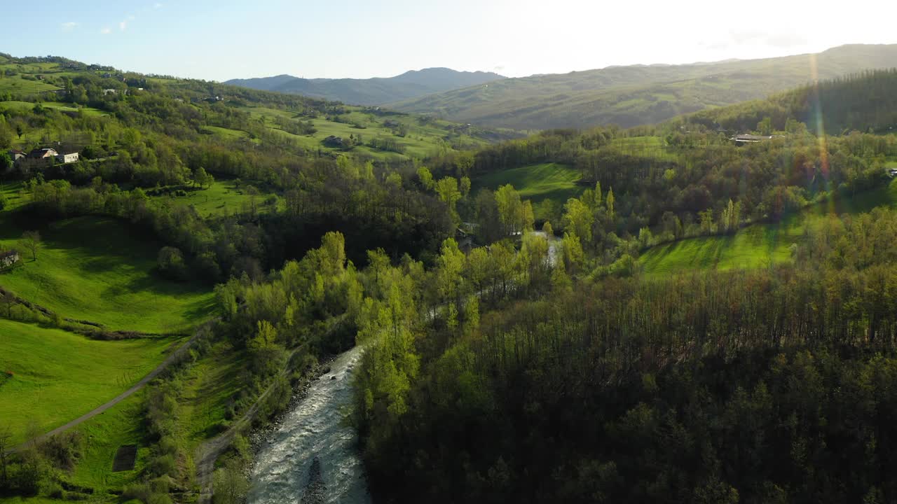 空中美丽的河水在山丘上流动，无人机向前飞行在绿色景观-亚平宁山脉，意大利视频素材