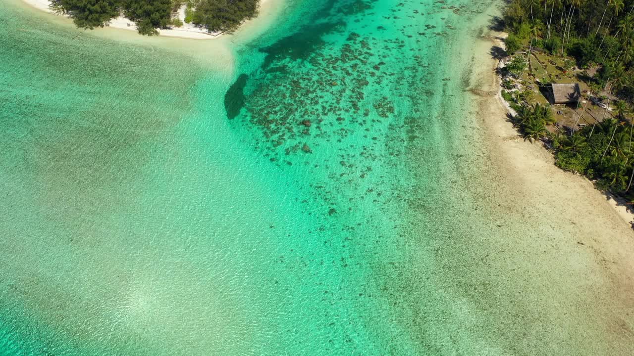 在阳光明媚的日子里，蓝绿色的海洋在岛屿间的空中向前拍摄-法属波利尼西亚的塔希提视频素材