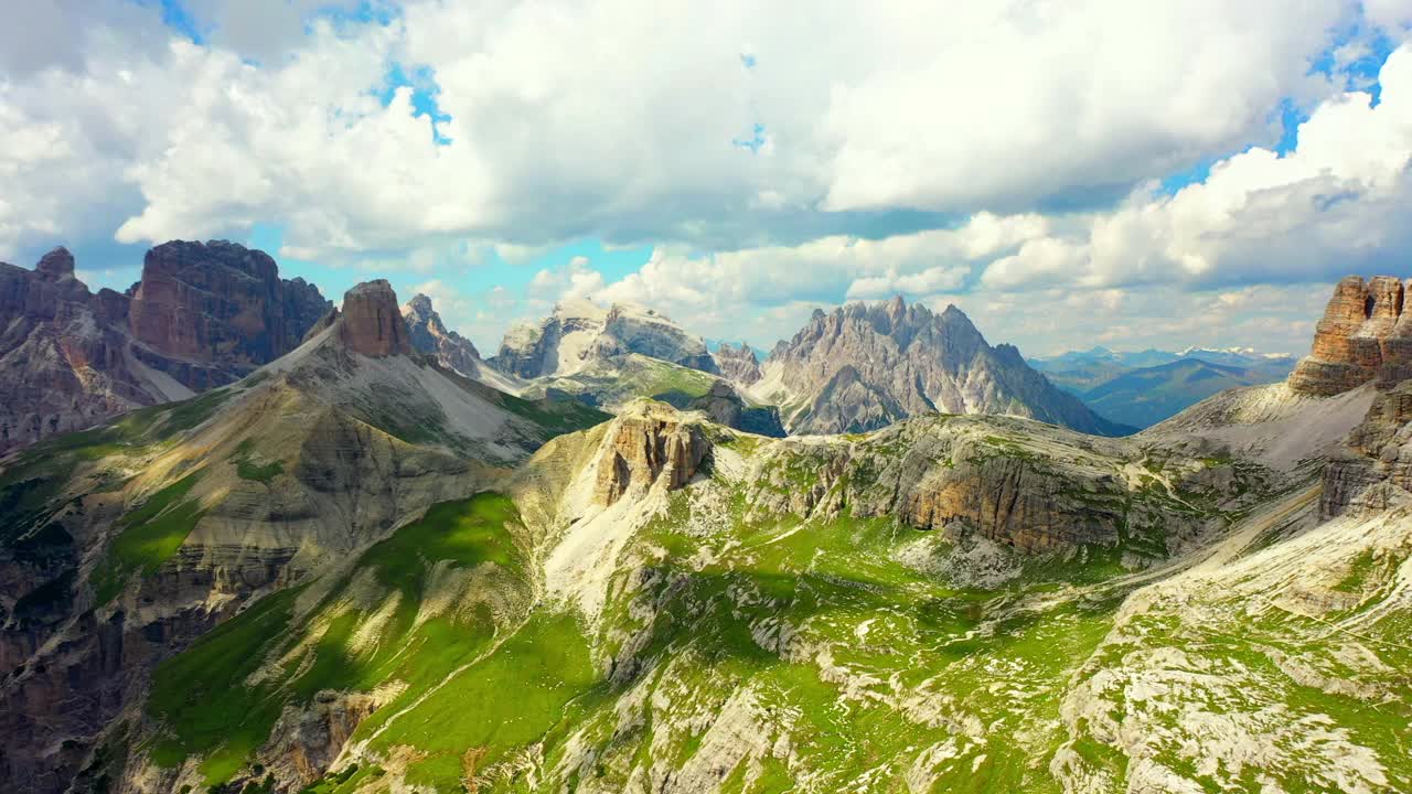 空中美丽的山脉在多云的天空，无人机飞行向前在绿色景观- Tre Cime Di Lavaredo，意大利视频素材